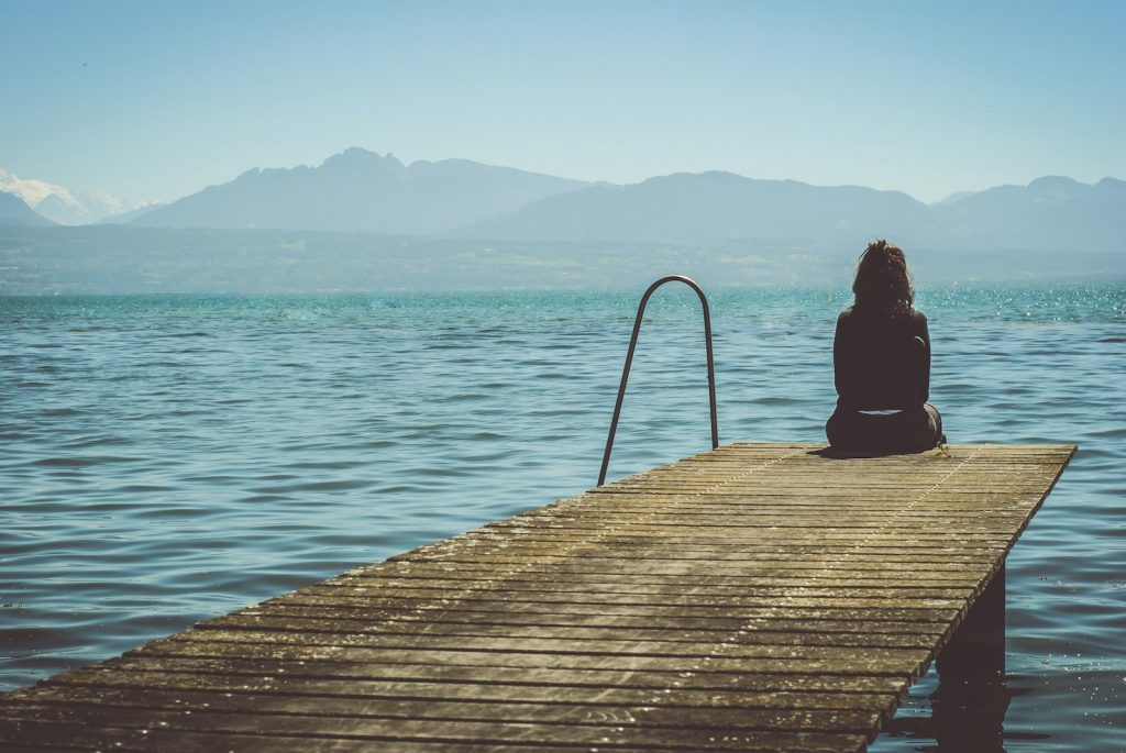 Women sitting on dock suffering from Depression in need of treatment