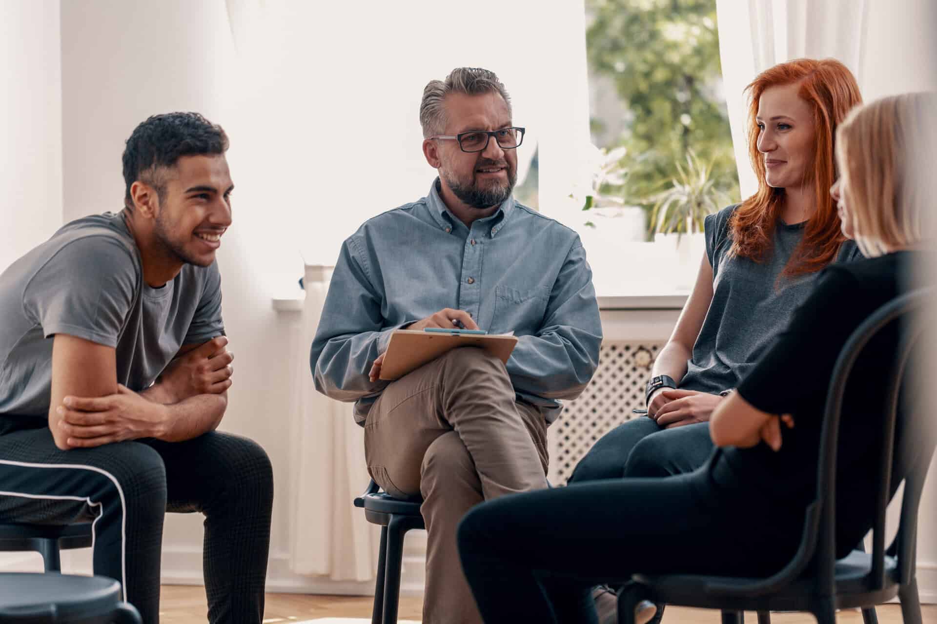 sober living in Pennsylvania Smiling Spanish man talking with friends during meeting for adults with therapist talking about sober living in Pennsylvania